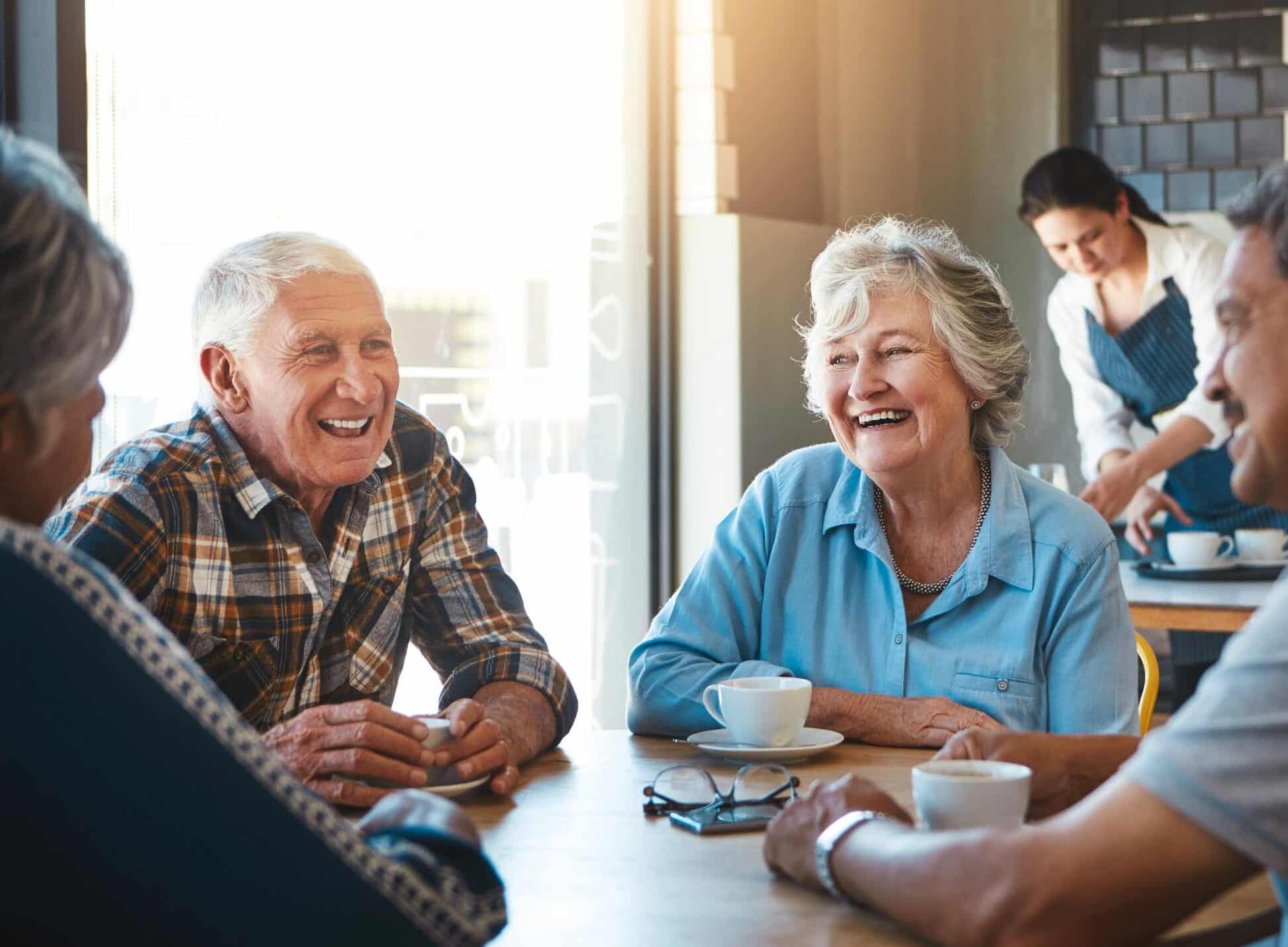 Senior couple enjoying coffee with friends