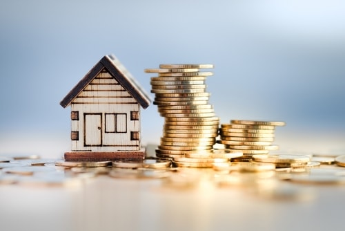 Photo of model house and stack of coins