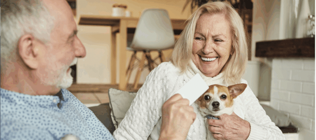 Smiling older couple with dogs in their living room