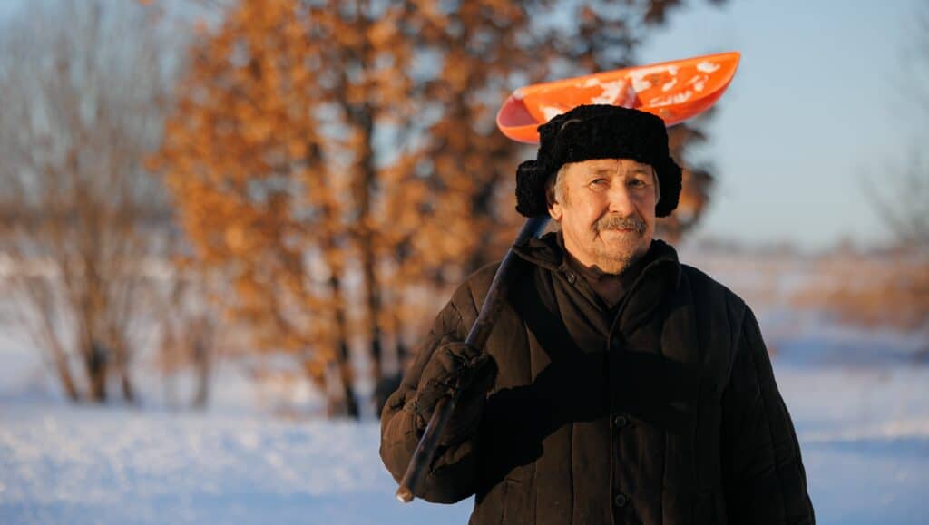 Elderly man with snow shovel